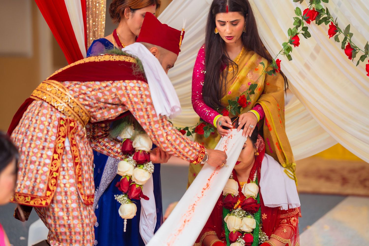 Wedding ritual ceremony showing exchange of garlands and traditional customs under decorated mandap.