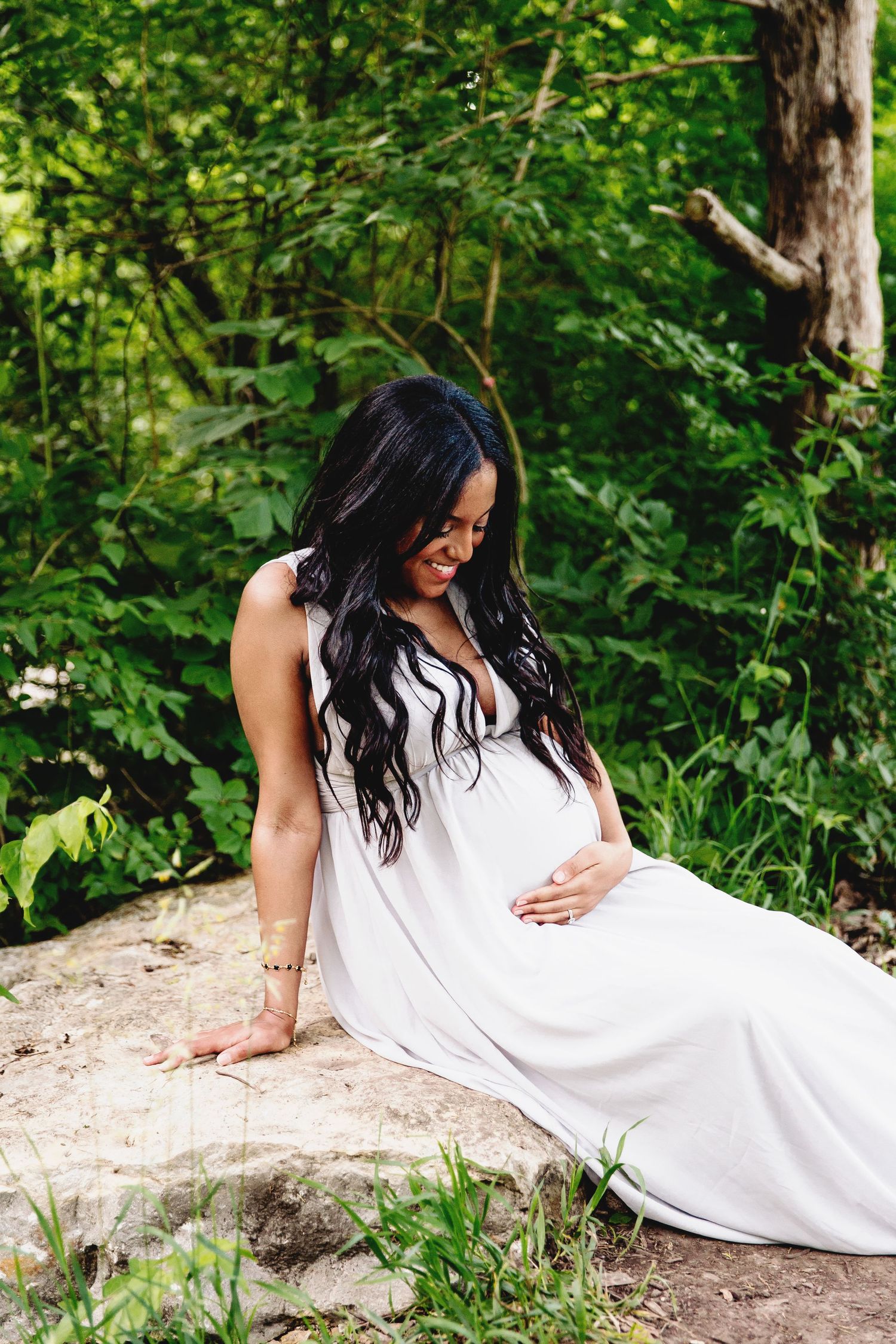 expecting mother smiling and looking at her pregnant belly