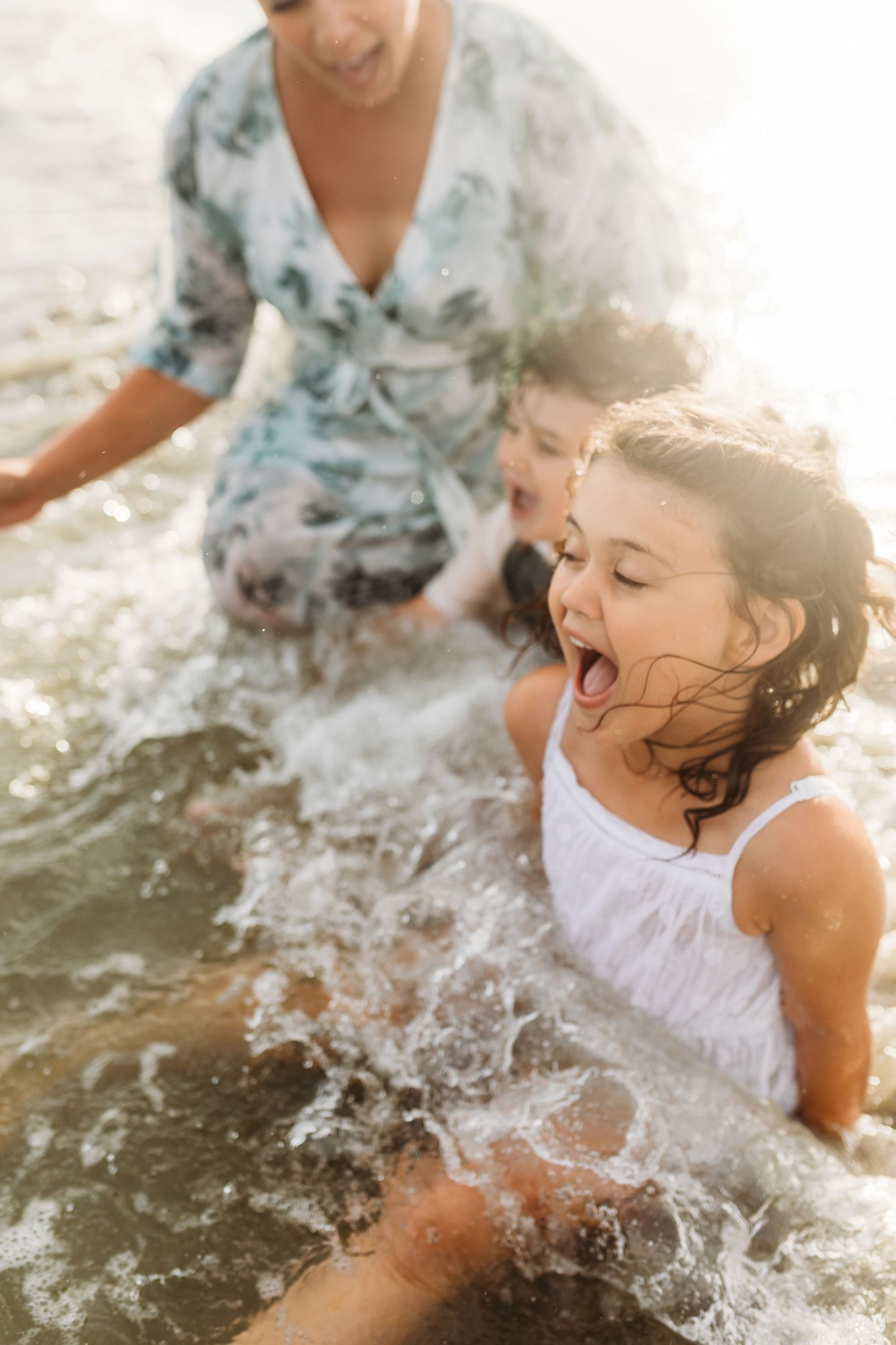 A joyful moment splashing in ocean waves at sunset.