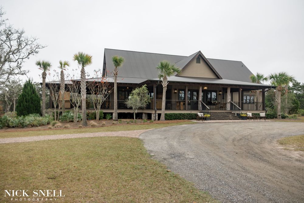 Elegant wedding venue exterior with gravel driveway and landscaped grounds.
