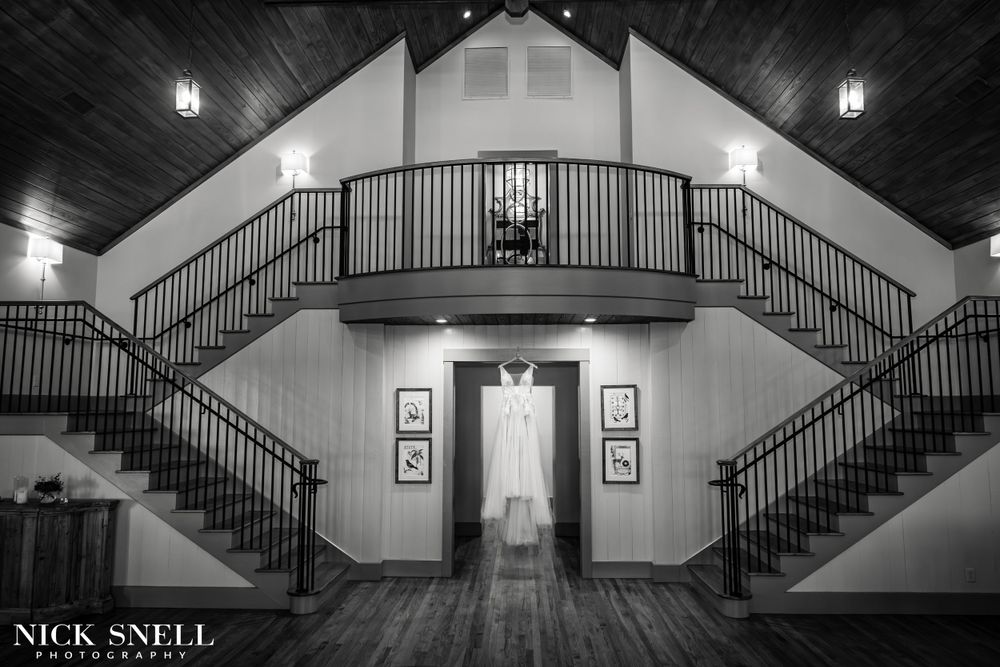 Dramatic black and white interior of wedding venue with grand staircase and vaulted ceiling.