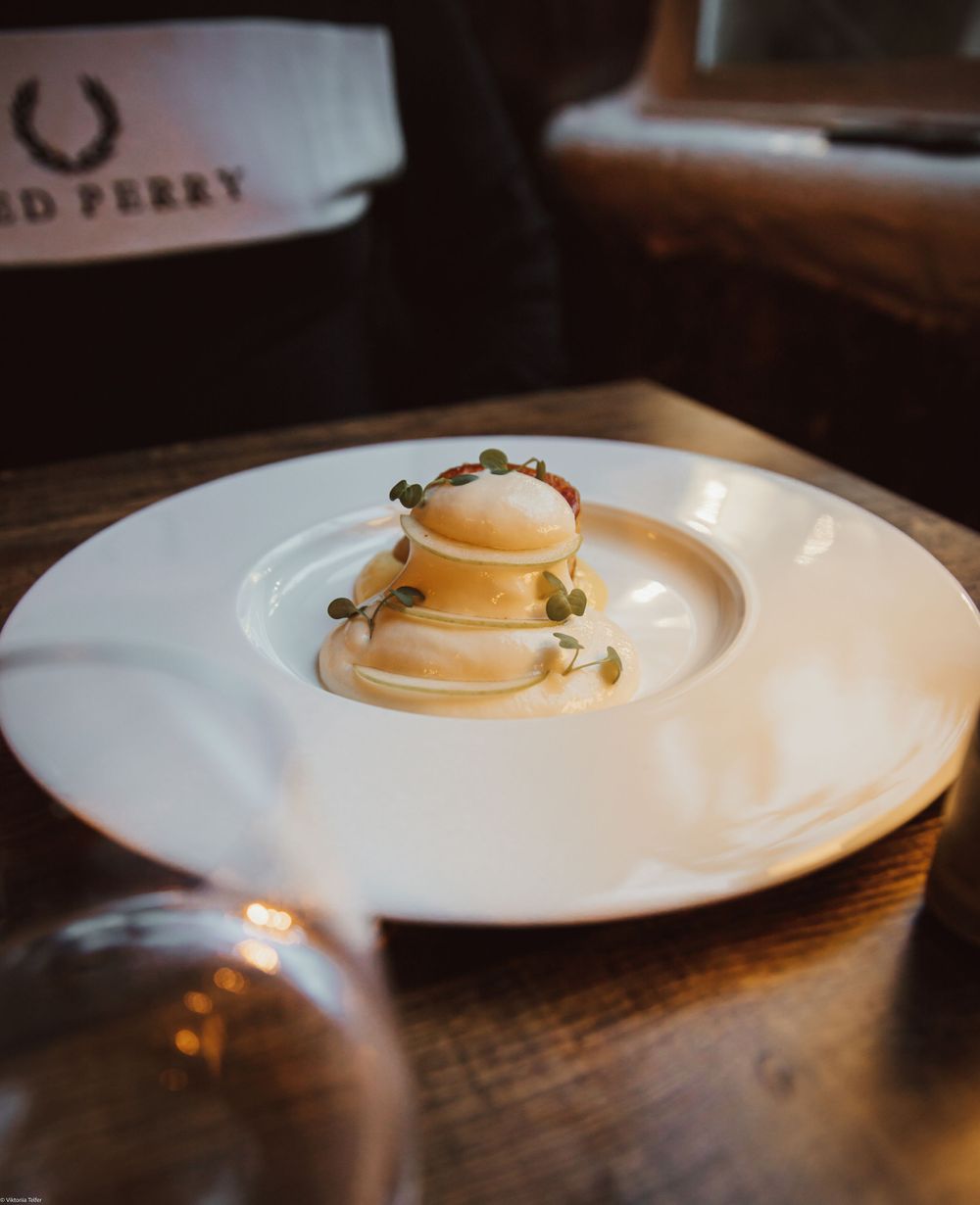 White plate with pancakes served on a dark wooden table with moody lighting.