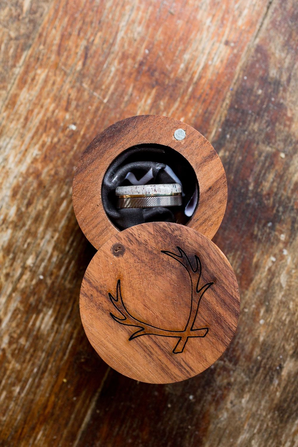 A wooden ring box with mountain design engraved on the lid.