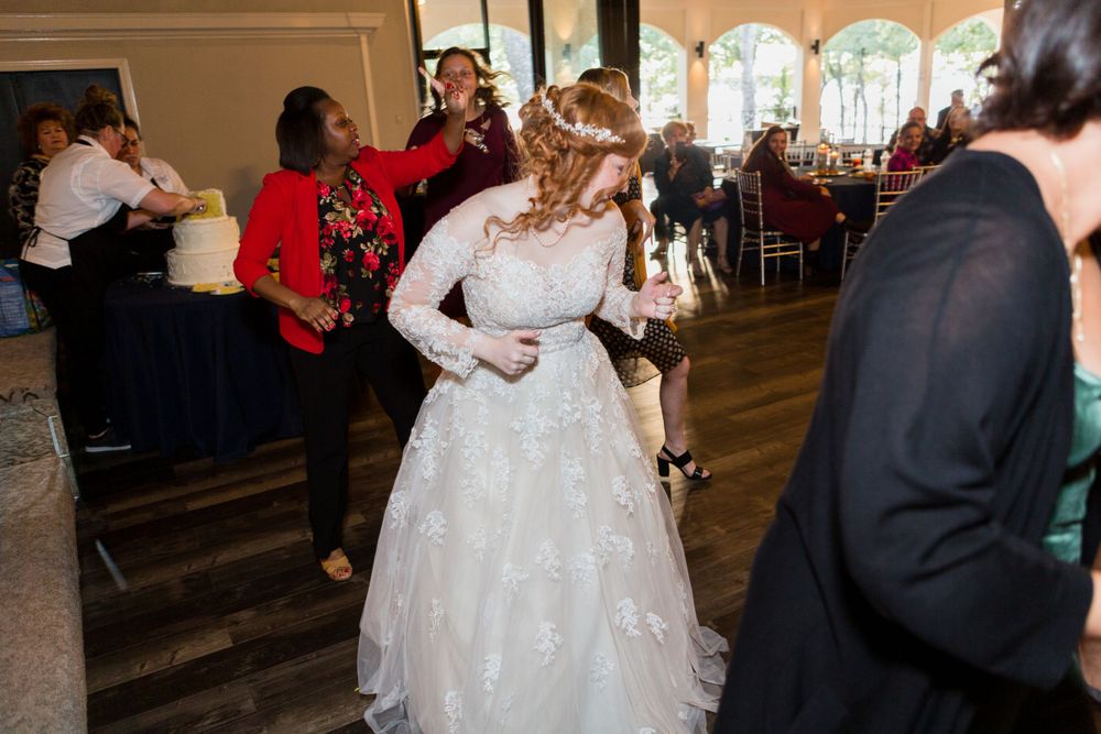 Couple dancing at their wedding reception surrounded by guests in a grand ballroom.