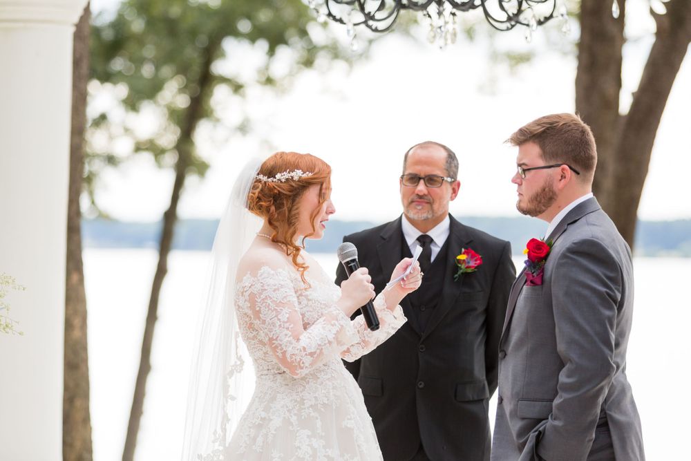 Wedding ceremony in progress with officiant and couple at waterfront venue.
