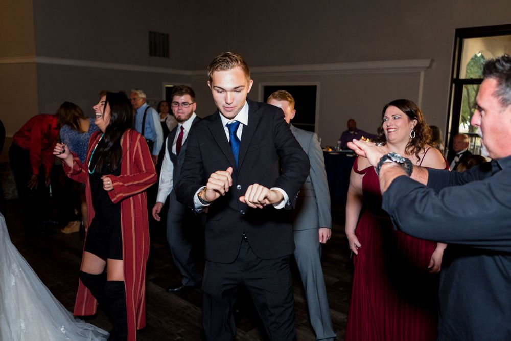 Guest showing off dance moves at a wedding reception with crowd watching.