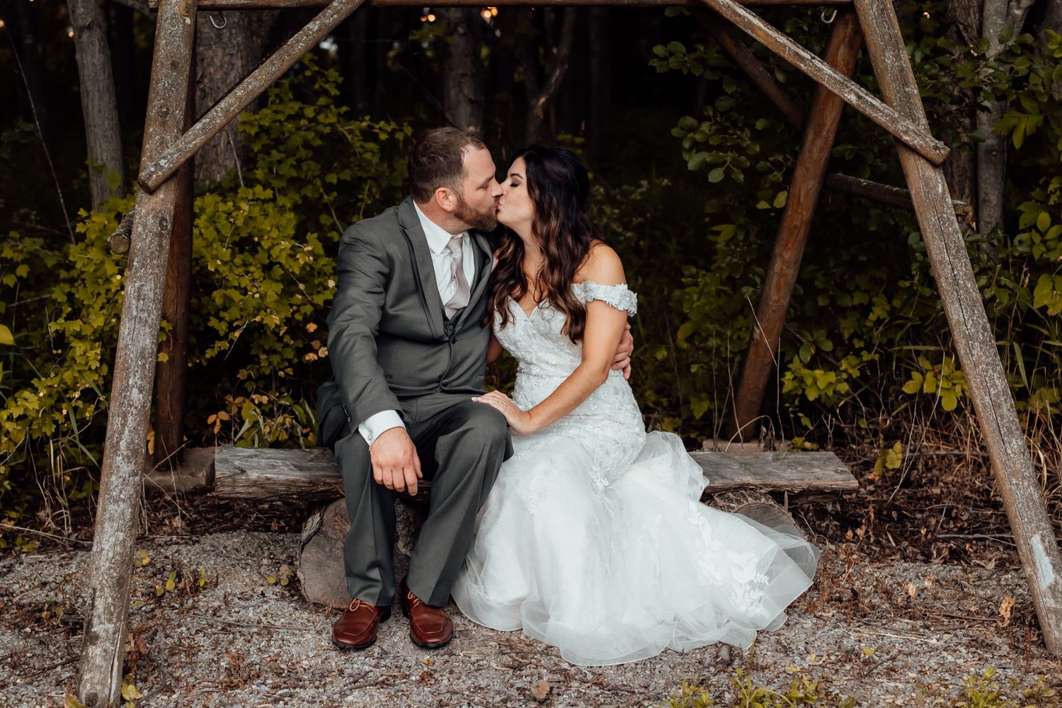 Newlyweds share tender moment on rustic wooden swing.
Janesville, WI
Brodhead, WI