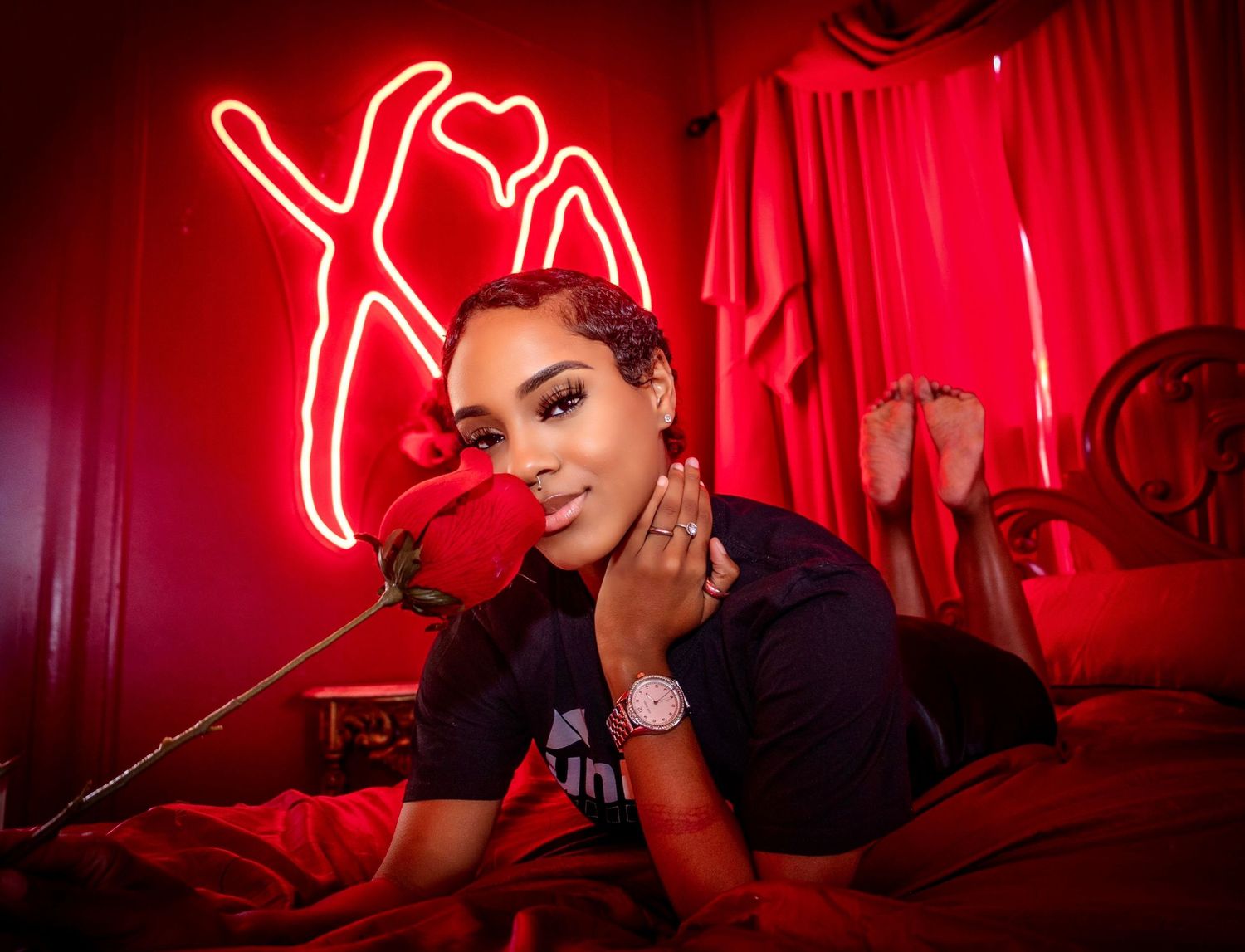 Portrait in red room with neon sign and decorative rose.