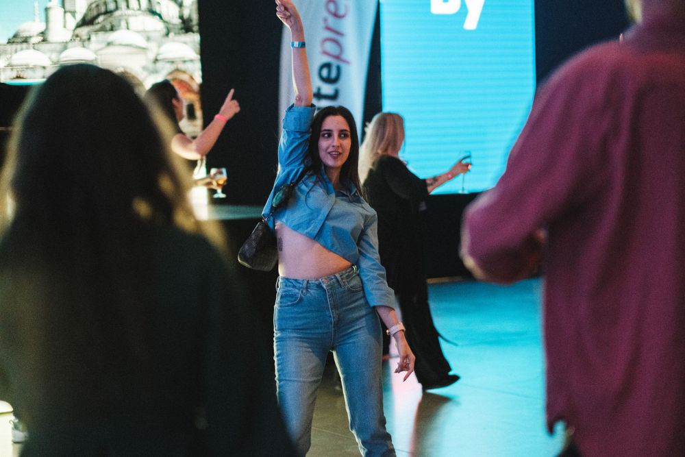 Performer engaging with audience in front of illuminated display screen.