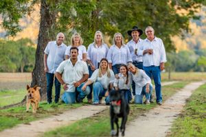 Casual group portrait on a tree-lined path with dogs in the foreground.