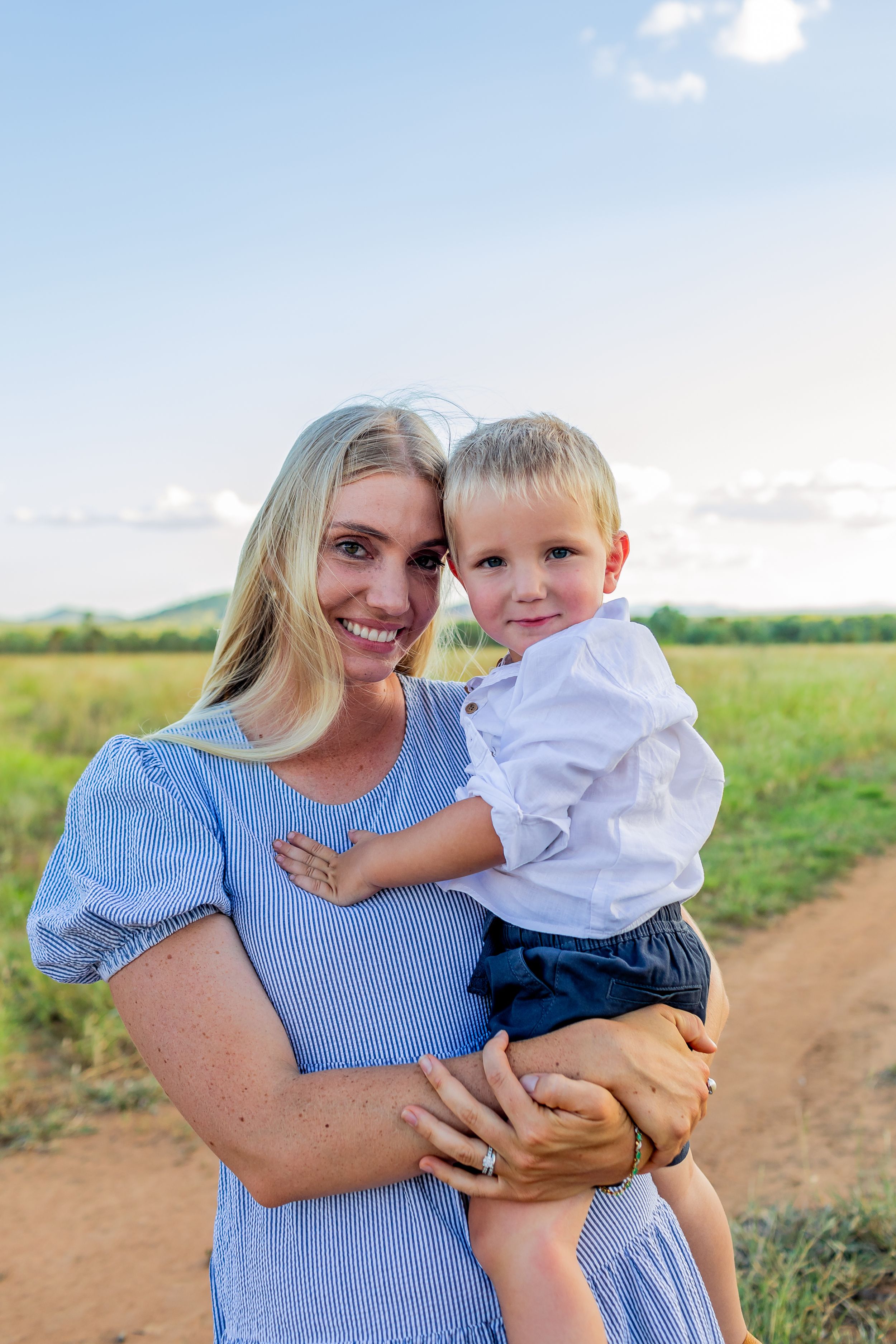 Portrait in field with soft natural lighting and rural backdrop.