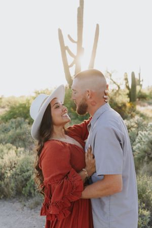 A romantic desert photoshoot with saguaro cacti silhouetted against the sky.