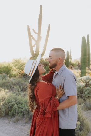 An intimate couple's portrait in a desert setting with saguaro cacti.