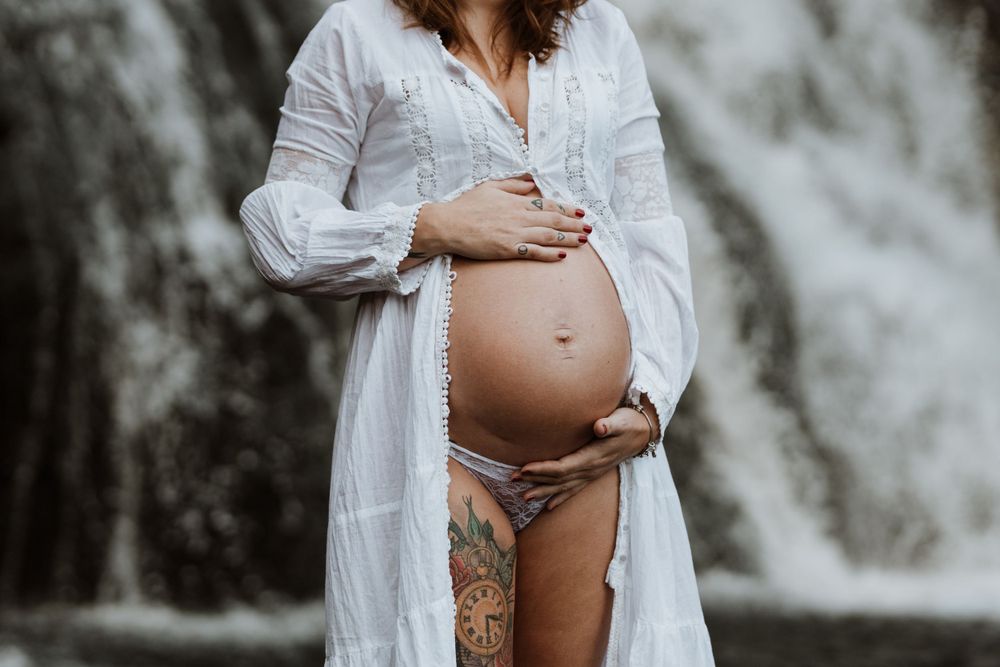 maternity bump under a waterfall