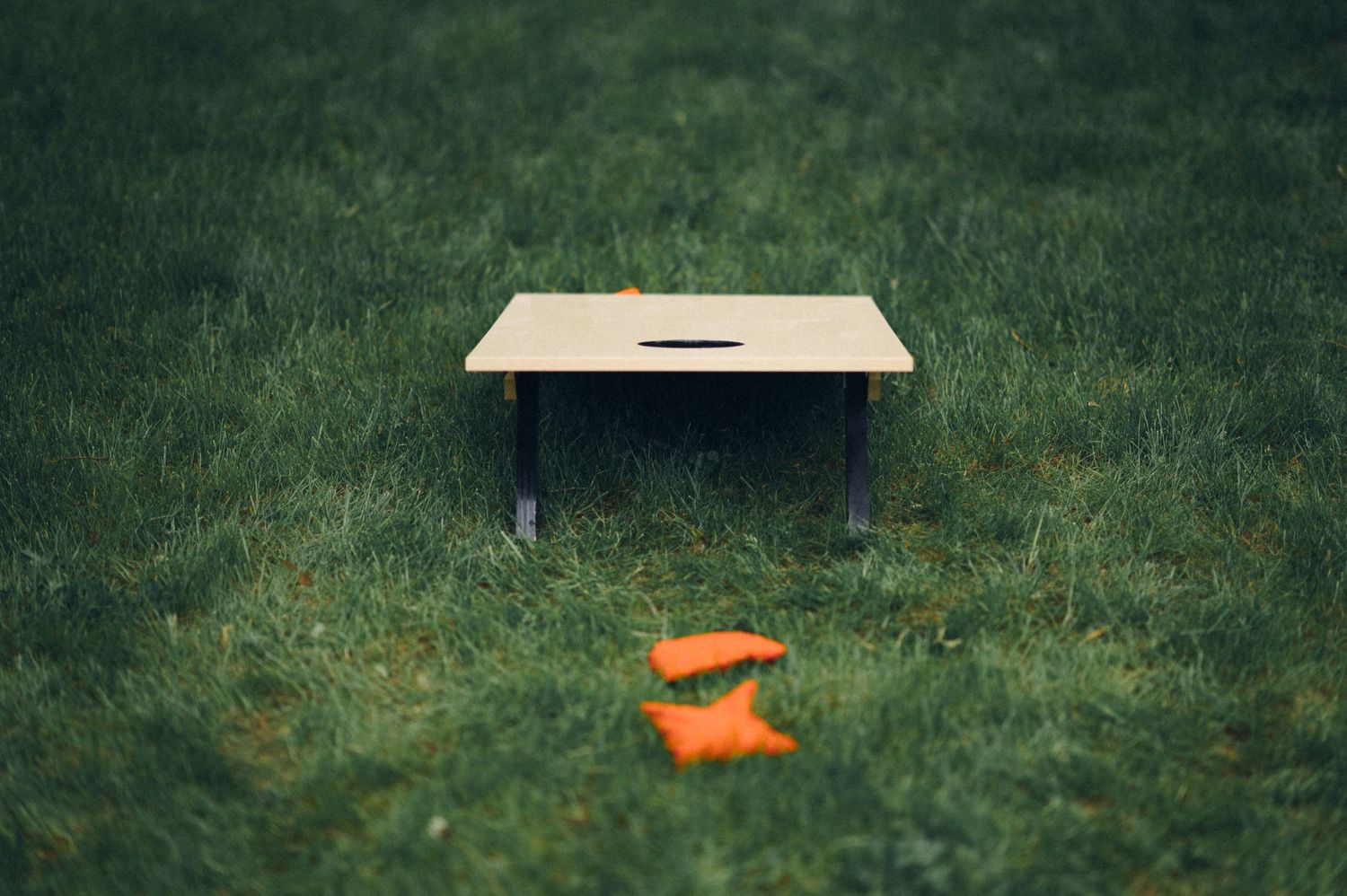 Wooden box placed on grass with orange objects nearby.