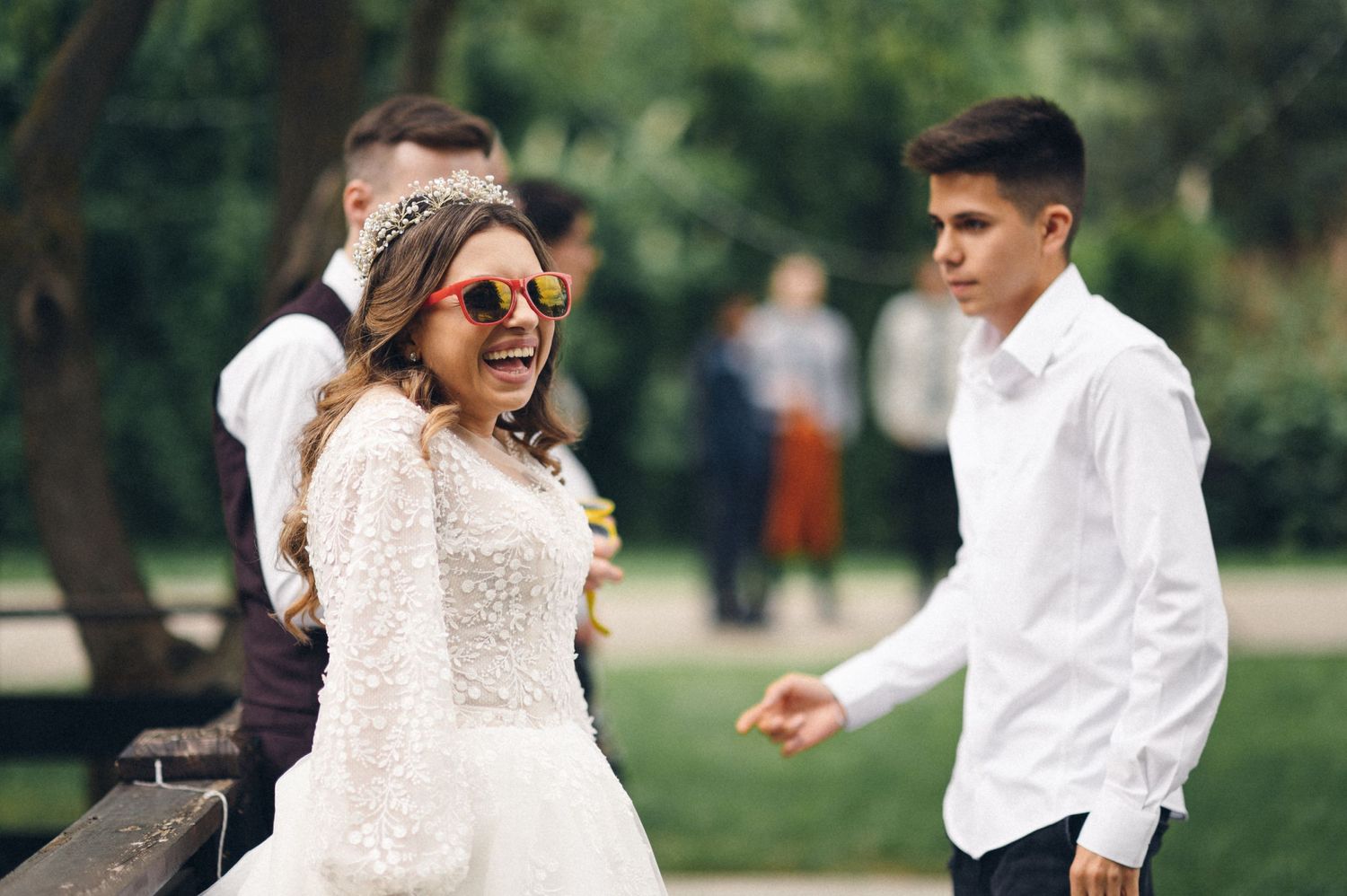 Wedding guests in sunglasses enjoying an outdoor celebration on a sunny day.