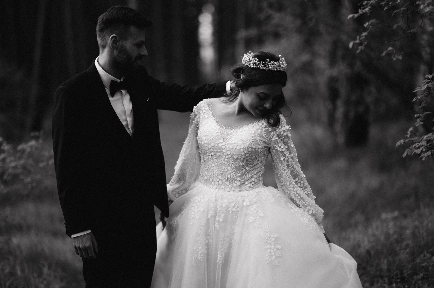 Black and white portrait of wedding couple in intimate forest setting.