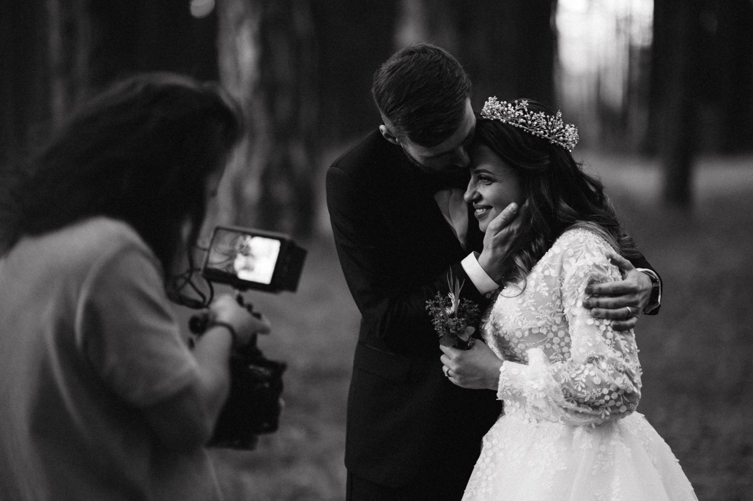 Behind the scenes of wedding photographer capturing intimate moment between newlyweds.