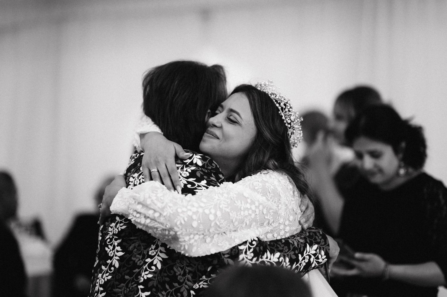 An intimate black and white moment captured during a wedding reception embrace.