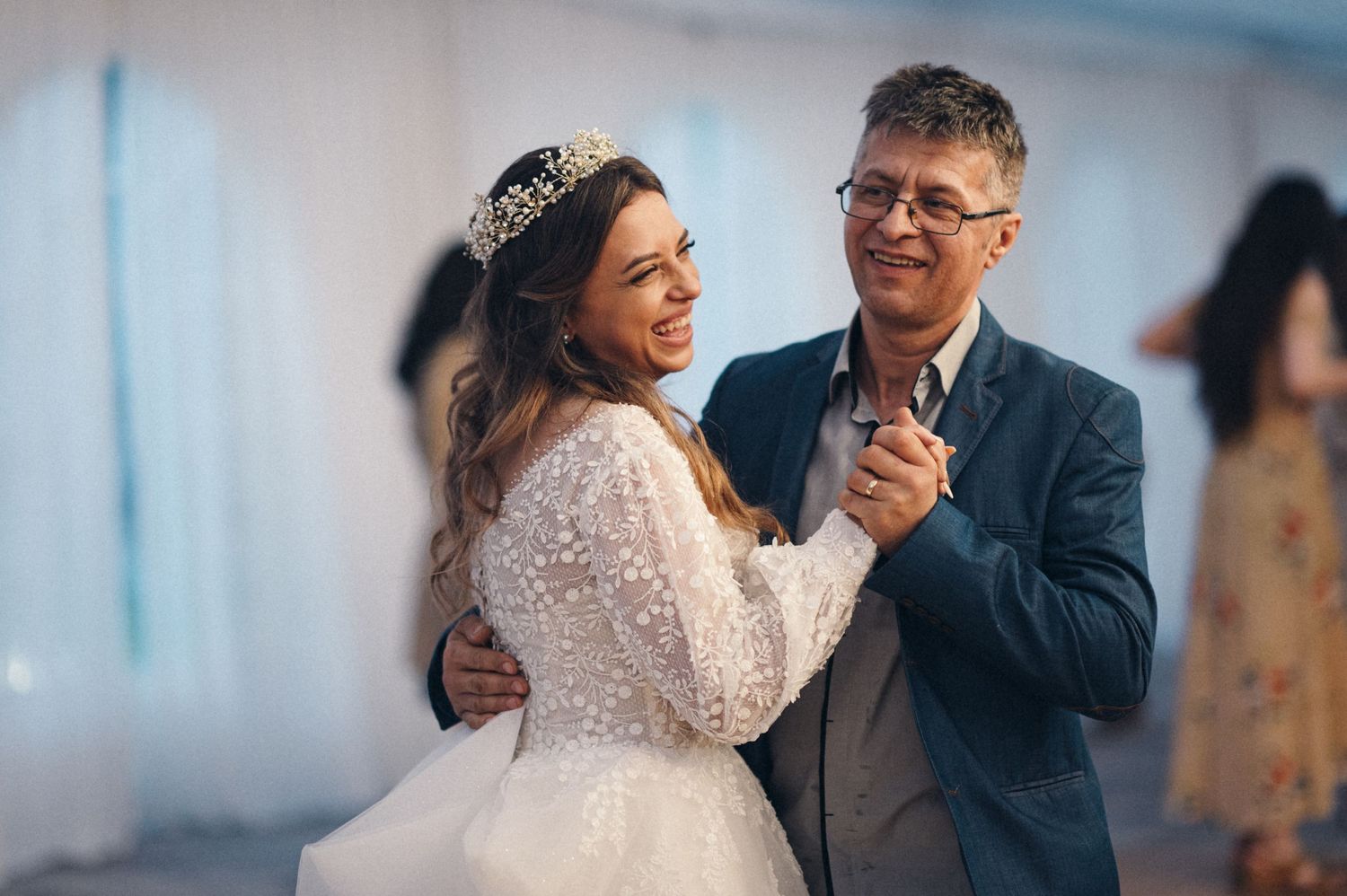 A joyful dance moment captured during a wedding reception under soft lighting.