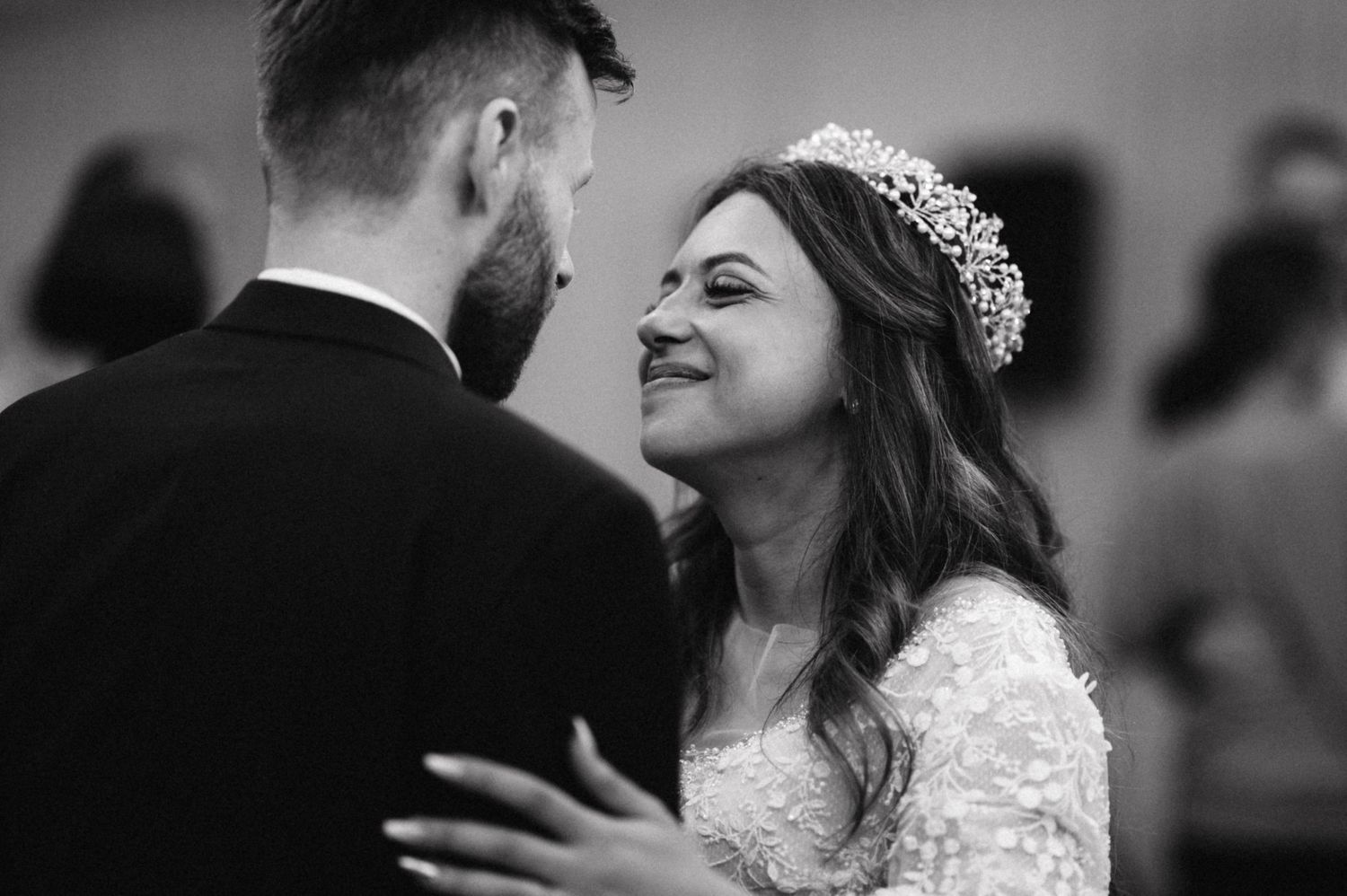 Intimate black and white photo of a couple sharing a joyful moment during their wedding dance.