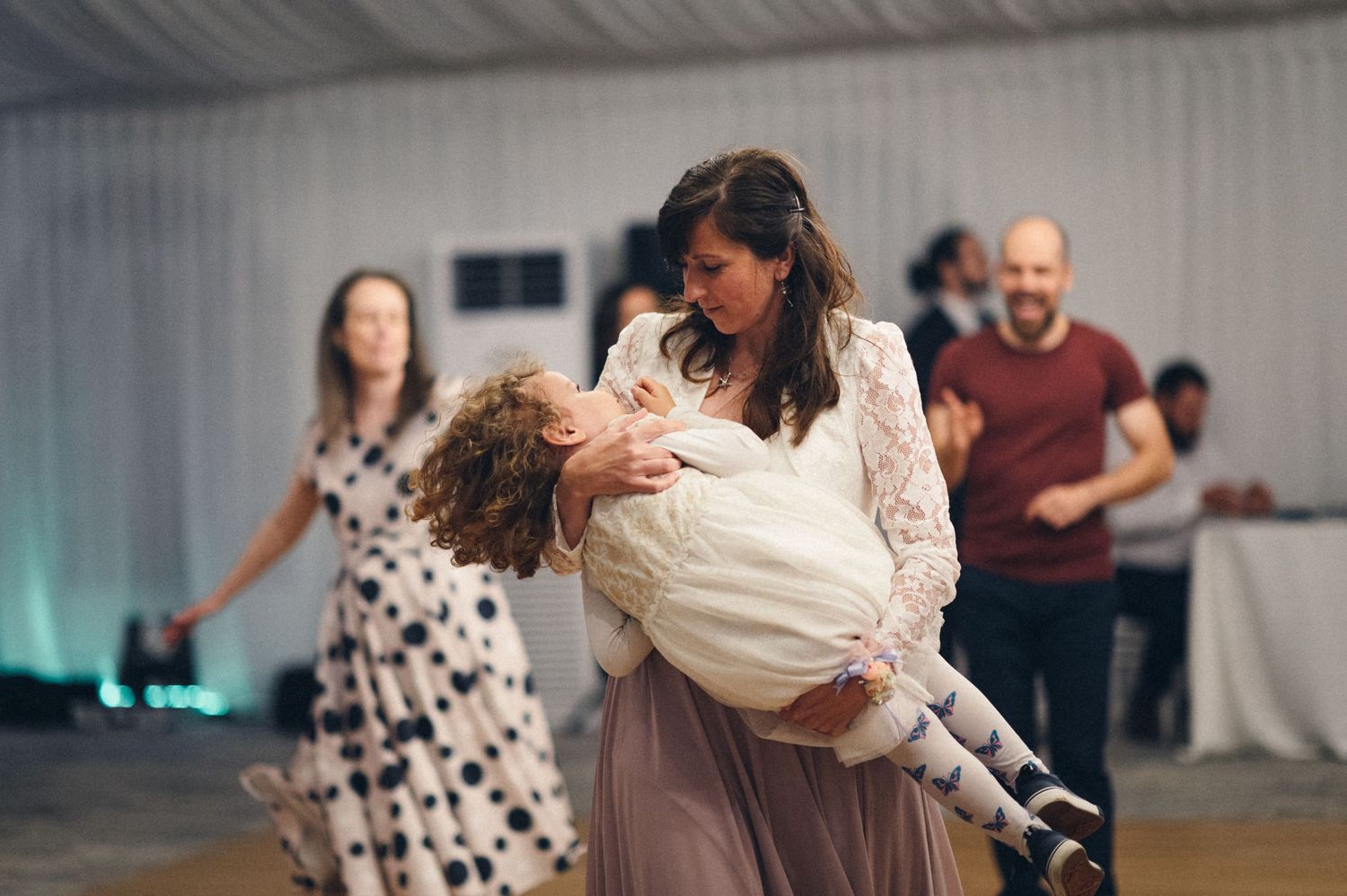Two people sharing a playful dance moment at a wedding reception.
