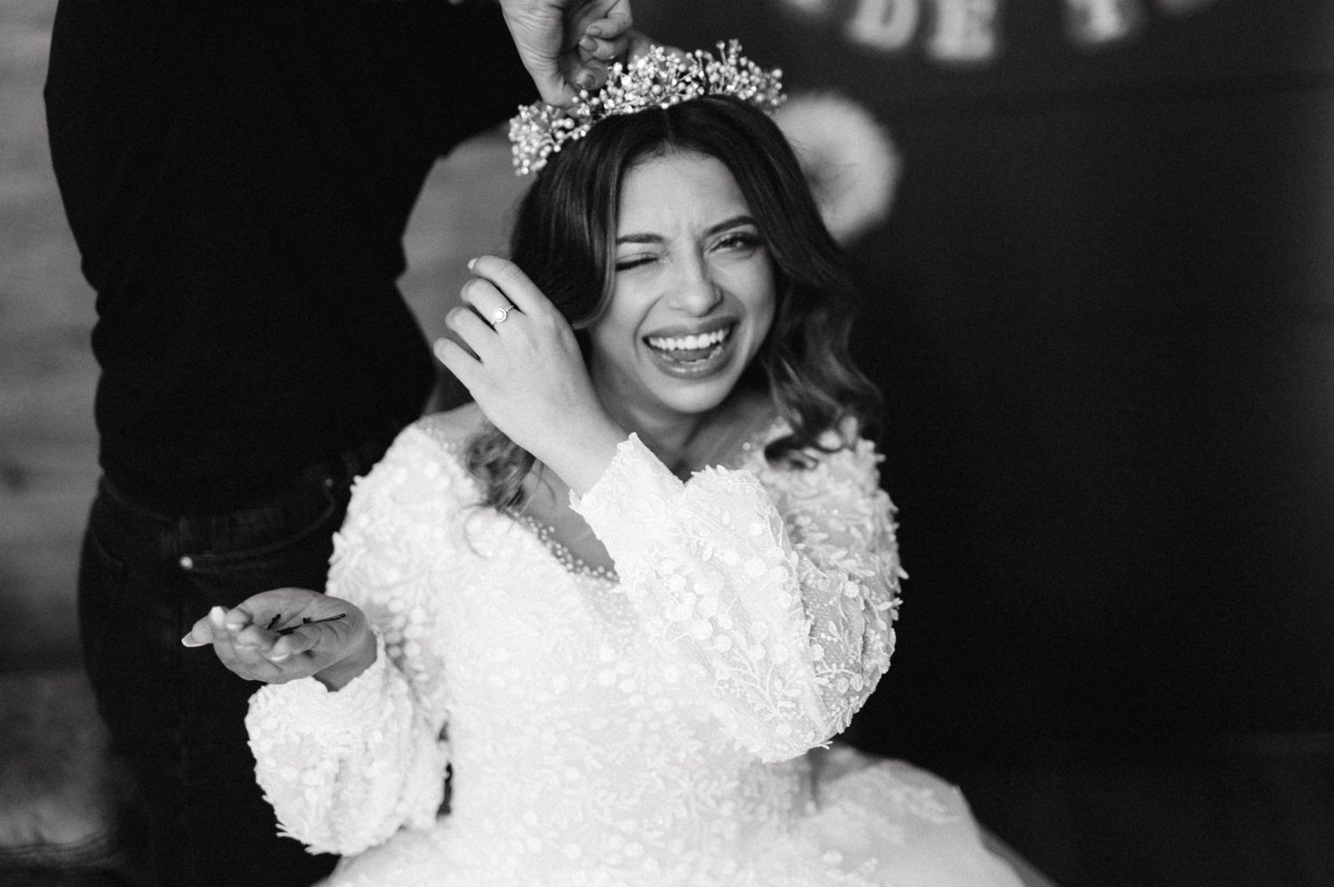 Black and white portrait of person in wedding dress wearing crystal crown.
