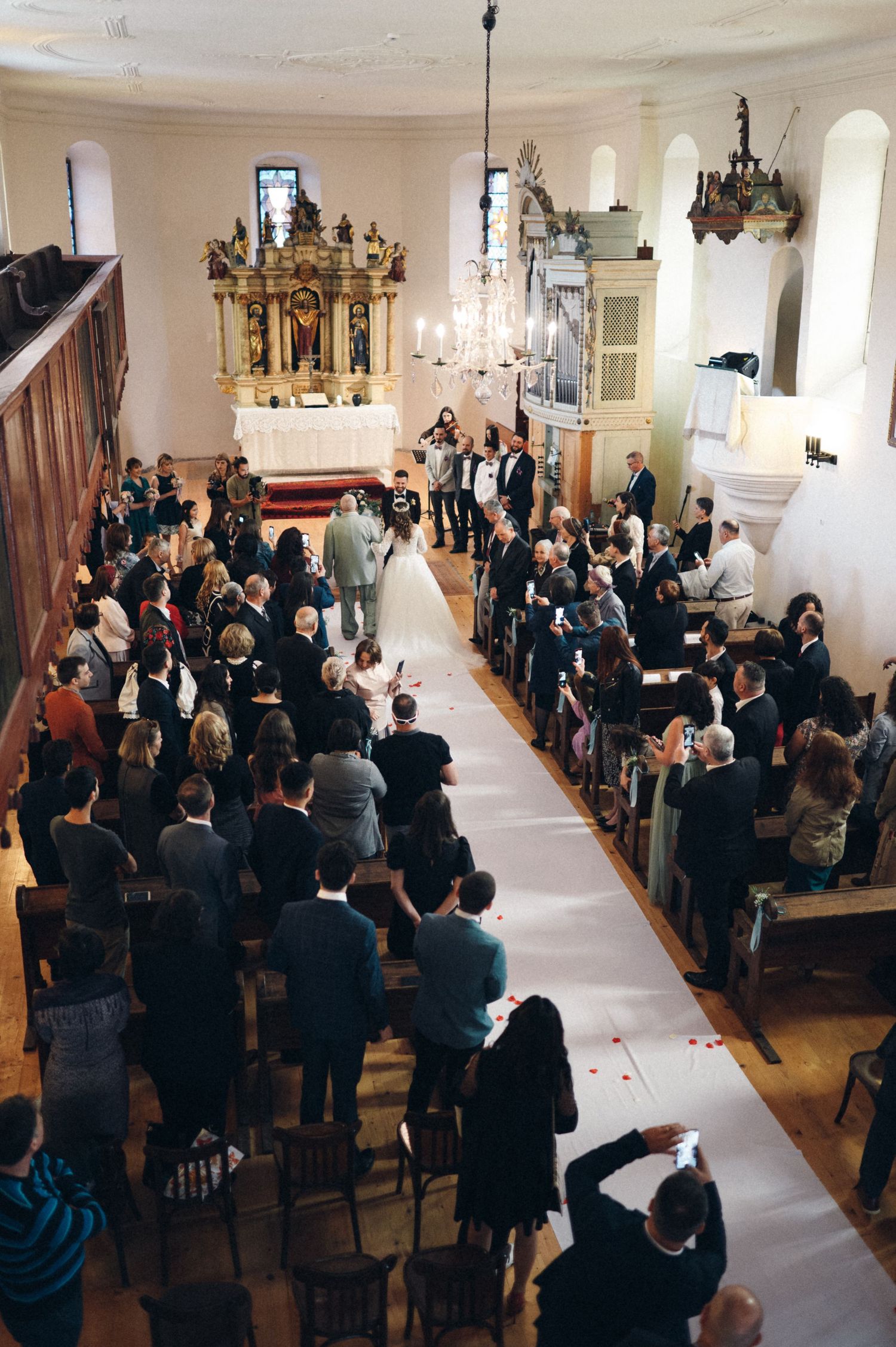 Aerial view of a traditional church wedding ceremony with guests lining the aisle.