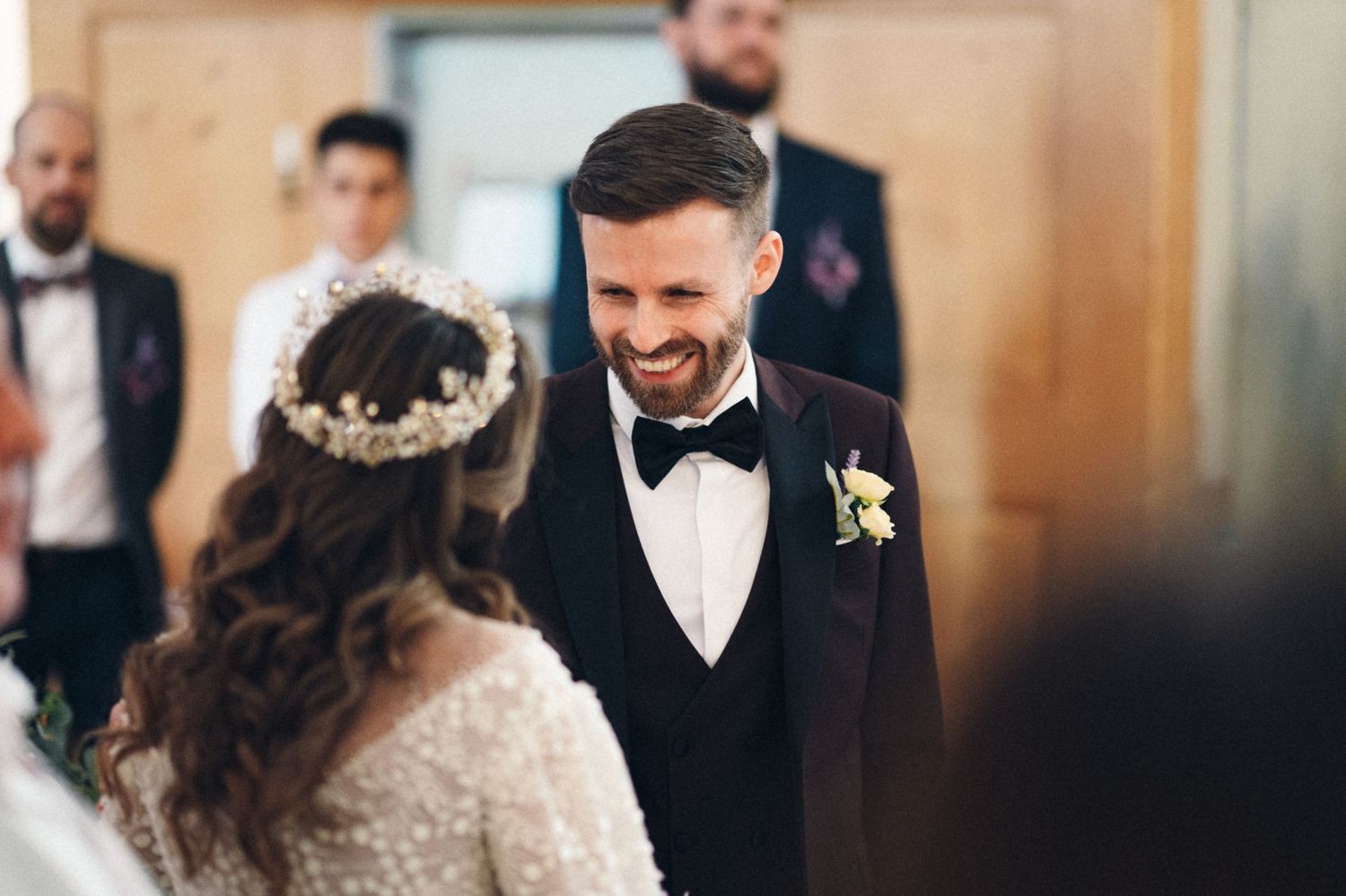 Beautiful church wedding ceremony with ornate gold altar and rose petals scattered on floor.