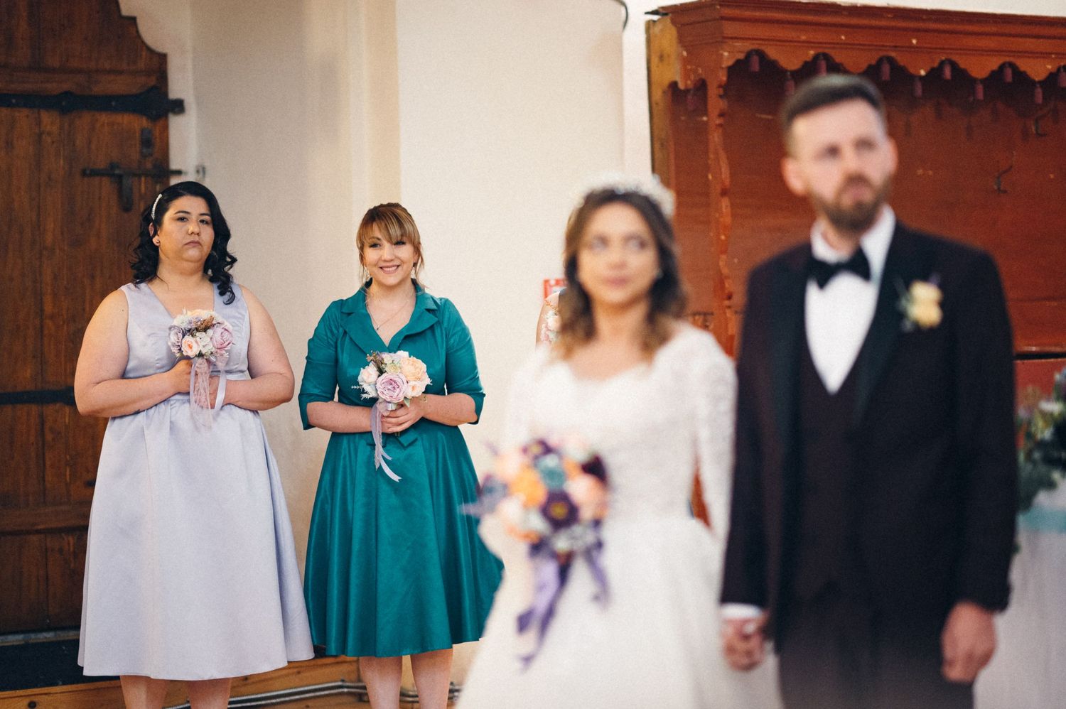 Classic black and white wedding ceremony photo in traditional church setting.
