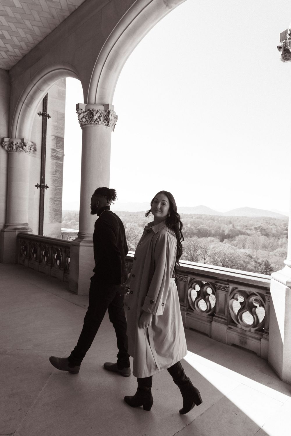 A couple enjoying the mountain view from the ornate stone balcony of Biltmore Estate.