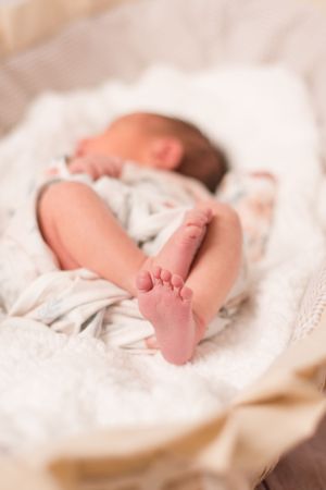baby in basinet with her little feet poking out. only her feet are in focus.