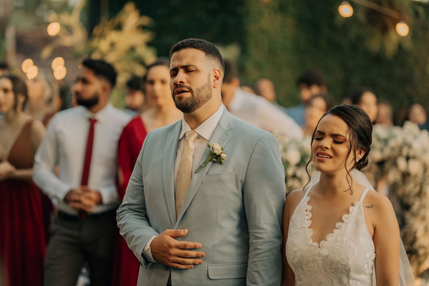 A newlywed couple shares a joyful moment during their outdoor wedding reception.