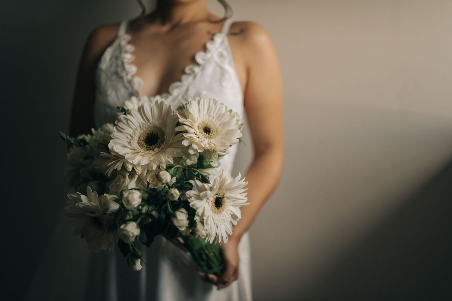 Close-up of a bridal bouquet with white gerbera daisies and delicate flowers.
