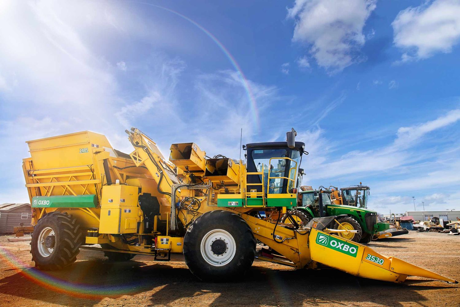 large heavy equipment  and tractors getting ready for harvest under a brilliant blue sky