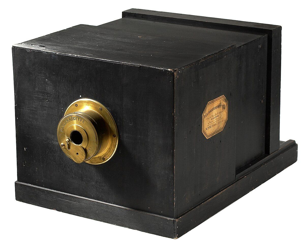 Early wooden box camera with brass lens mount from the dawn of photography.
