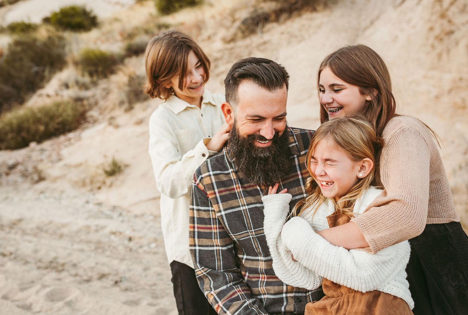 three kids hugs and laugh with their dad in redlands ca