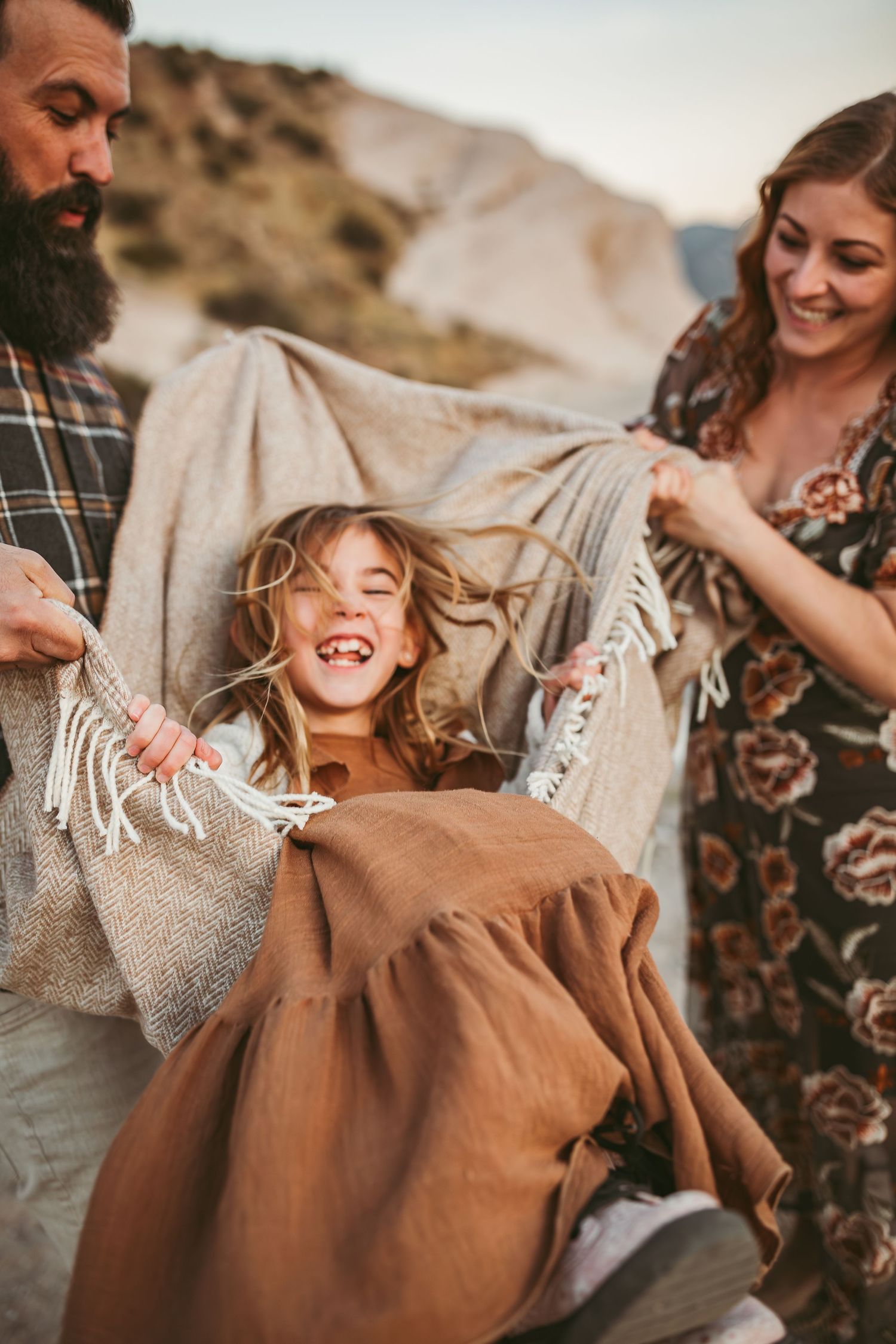 a young girl sits in a blanket and laughs in beaumont ca