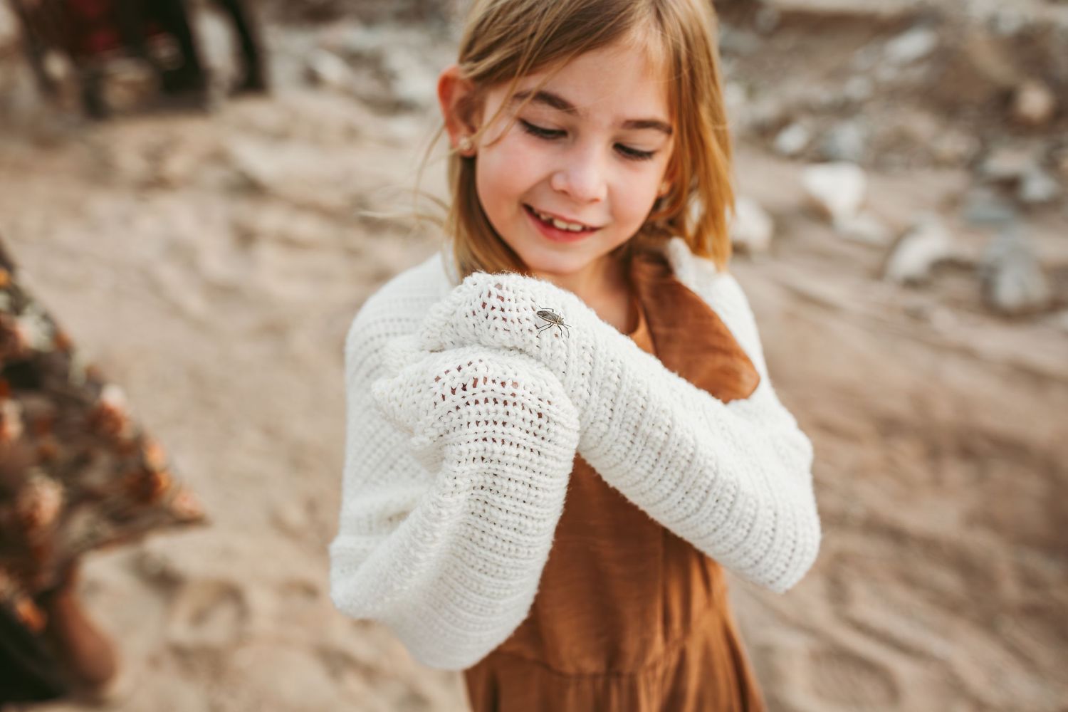 a young girl is looking at a bug that landed on her in calimes ca inland empire