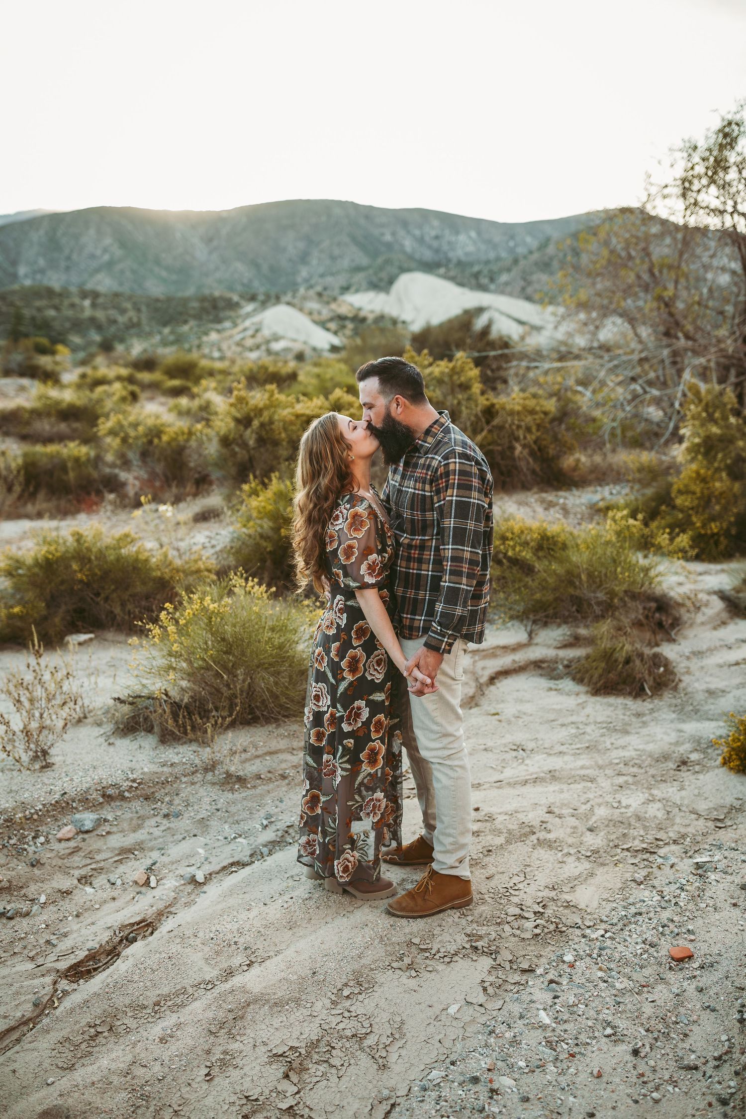 a married couple hold hands and dance in the high desert at sunset with heidi grace photography