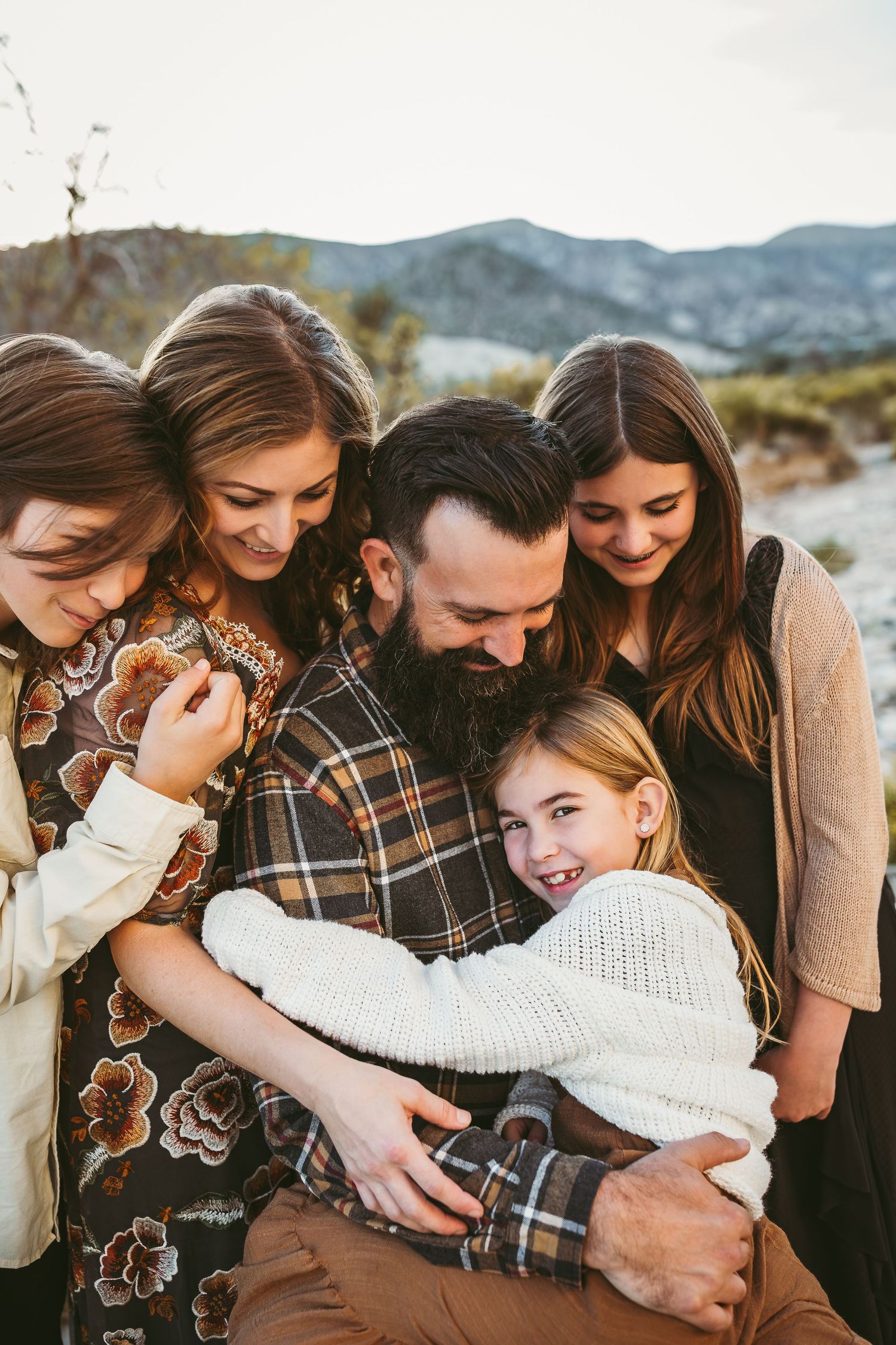 a family of five cuddling and laughing at a photo session in beaumont ca