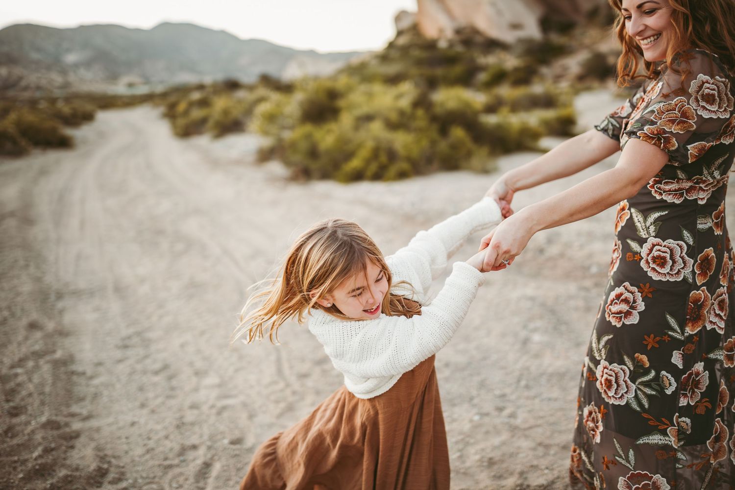 a mom and daughter dancing in the desert in southern california