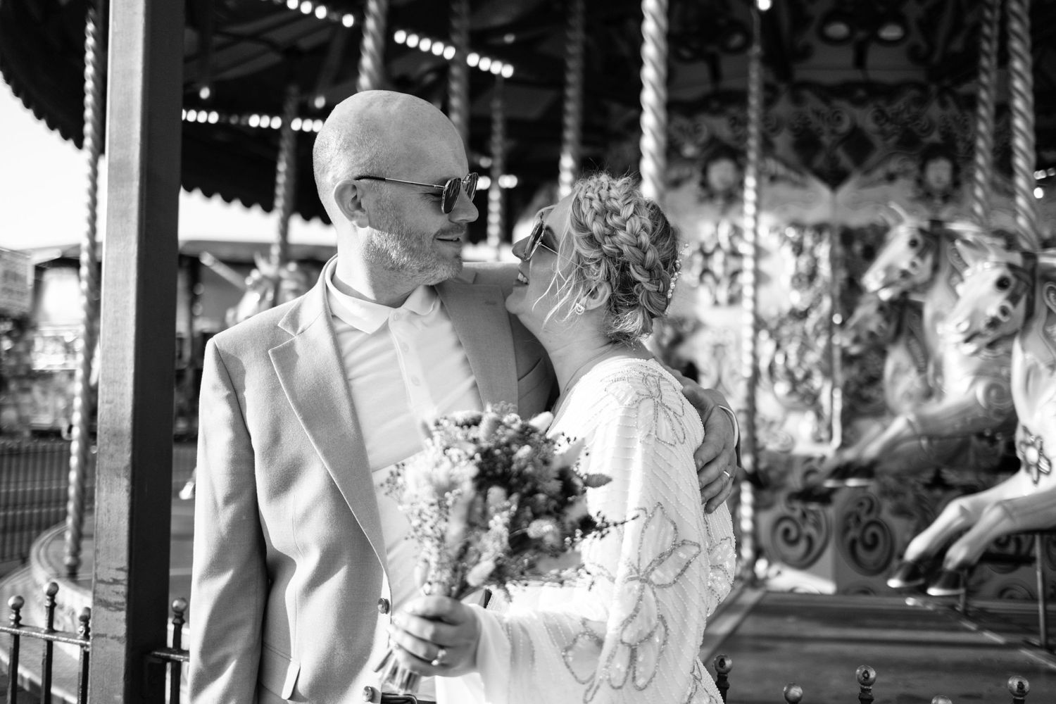 bride and groom standing outside merry go round  alternative wedding