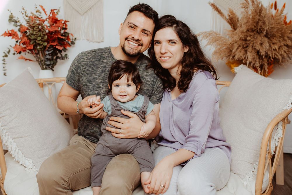 Family lifestyle photography session in a cozy home setting with warm neutral tones and dried floral decor.