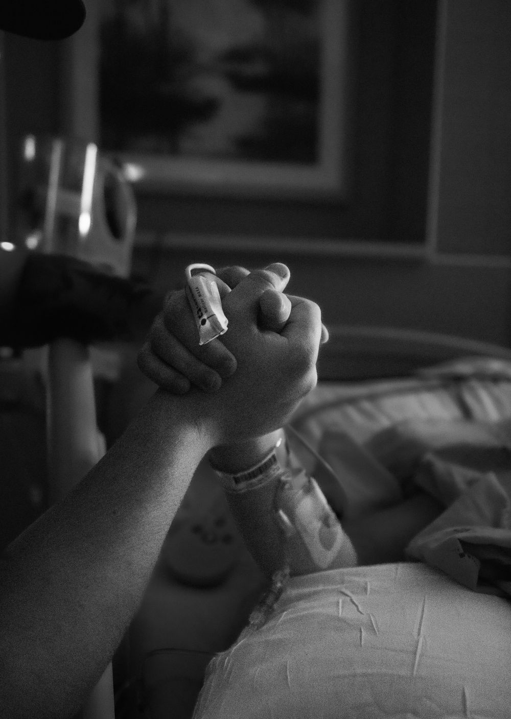 Medical professional holding patient's hand during hospital care.