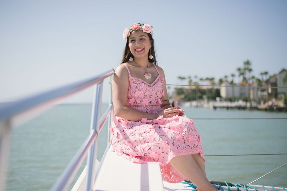 girl seating in a boat enjoying the sun. South Padre Island. Quinceanera. Wedding photography