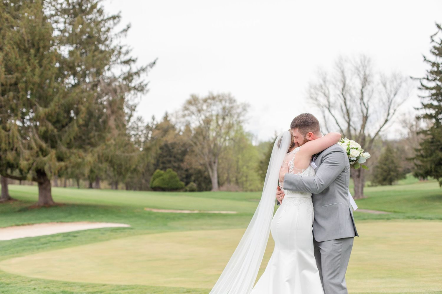 A touching wedding moment captured on a beautiful spring day at a golf course.