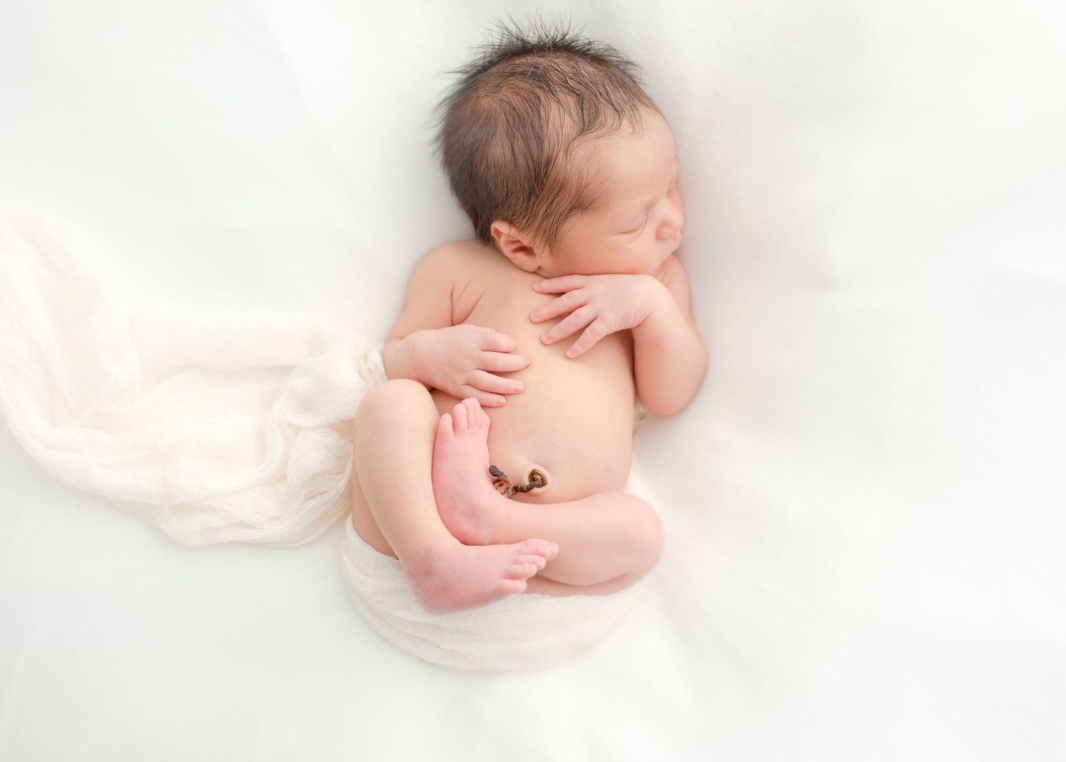 baby boy posing in a newborn studio photo shoot with his umbilical cord in houston texas