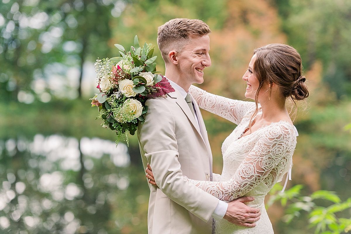Bride and groom smile at each other during wedding portraits