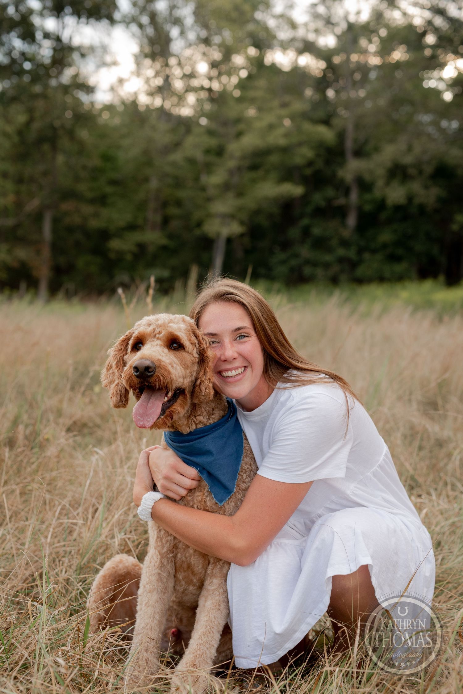 A joyful moment captured between a goldendoodle and someone in a white dress in a grassy field.